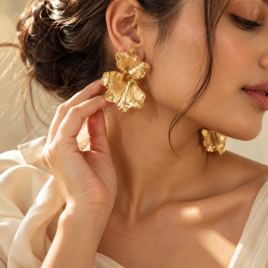 Woman wearing a large sculptural gold petal earring